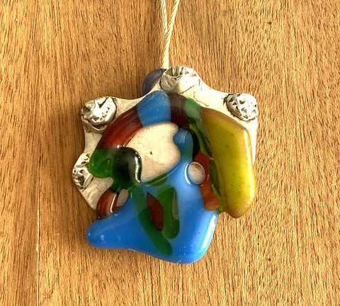 Een zilveren ketting met handgemaakte hanger van zilver met gefused glas
